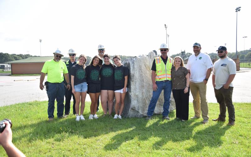 Pictured during delivery of a new boulder for the Franklin County High School campus are (from left) Georgia Stone Products (GSP) Carnesville Foreman Stoney Ervin; Bradlee Edins of GSP; FCHS Student Council members Emily Minish, Abigail Fowler, Peyton Dailey and Brooke Davitt; GSP District Manager Bill Wilson and wife Rebecca; Franklin County Athletic Director Jason Swiney; and Dawson Whaley of Whaley’s Hauling LLC.