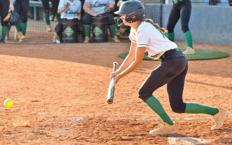 Senior Macy Moore lays down a bunt in a game earlier this season for the Lady Lions’ softball team.