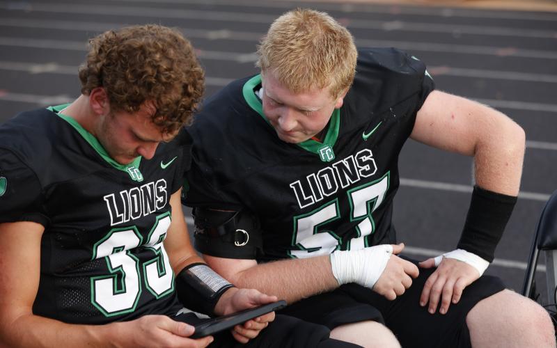 Keyes Harbin (No. 33) looks at a replay with Elijah London (No. 57). (Photo courtesy of Rachel Howington Photography)
