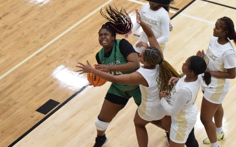 Takiyah Merriett battles for a rebound in action Thursday at Commerce. (Photos by Scoggins)