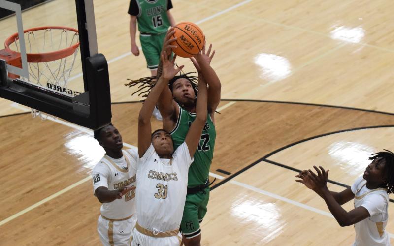 D.J. Appleby grabs a rebound over a Commerce player Thursday in a game at Commerce.