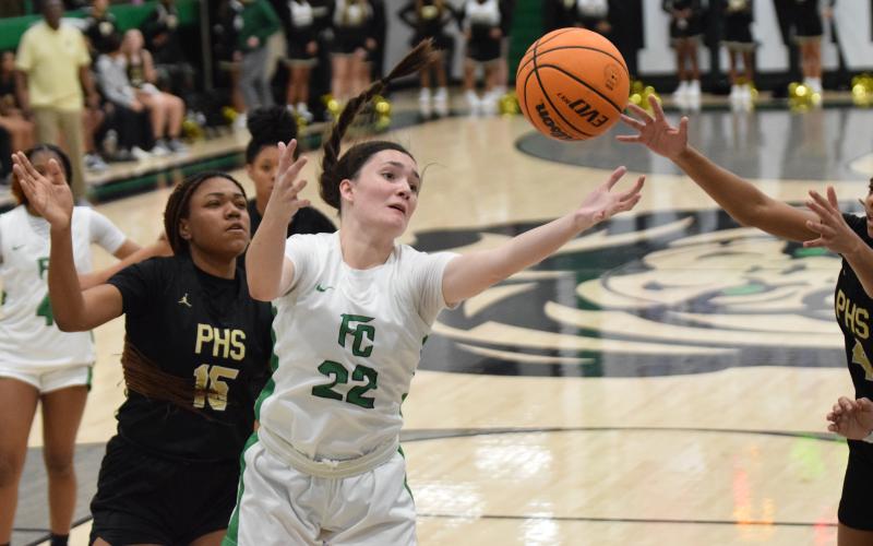Avery Burton reaches for a rebound Tuesday in action against Pendleton, S.C., in the Lion’s Den. (Photo by Scoggins)