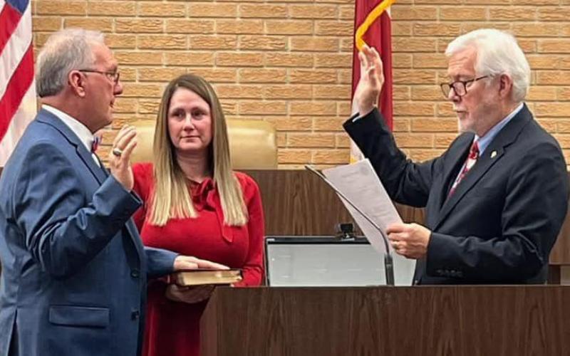 Incoming Northern Judicial Circuit Superior Court Judge Christopher NeSmith (left), with wife Melissa holding the Bible, is sworn in by Senior Judge John H. Bailey Friday at the Hart County Courthouse. (Photo courtesy of Patrick Fargason of The Hartwell Sun)