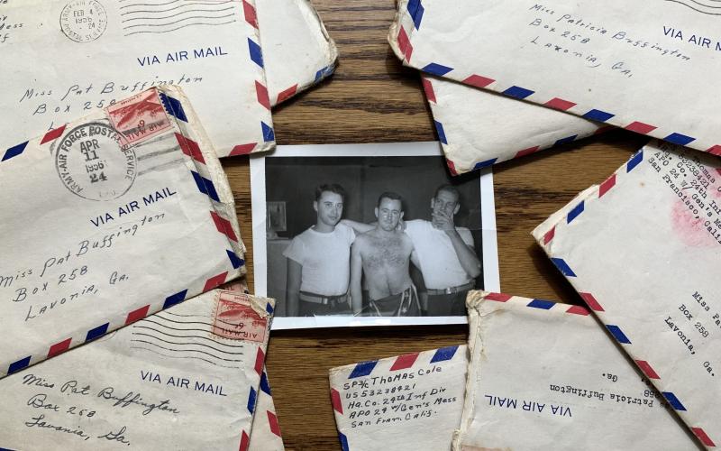 A photo of Tommy Cole with his friends Bill Austin and Ron Burdette lies on a table with letters he wrote to his future wife Trish while serving in Korea during the Korean War.