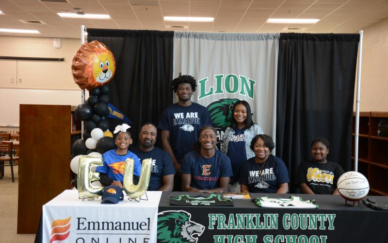 Franklin County High School senior Mylan Roebuck was surrounded by family and friends when he signed his scholarship to play basketball for Emmanuel University on Tuesday. Members of his family there for the occasion were (front, from left) Aubree Roebuck, Bernard Roebuck, Mylan, D’Anna Roebuck, Amiracle Roebuck, (back) Micah Roebuck and Alexus Burton. Mylan will join his brother Micah on the Emmanuel Lions basketball team. (Photo by Eavenson)