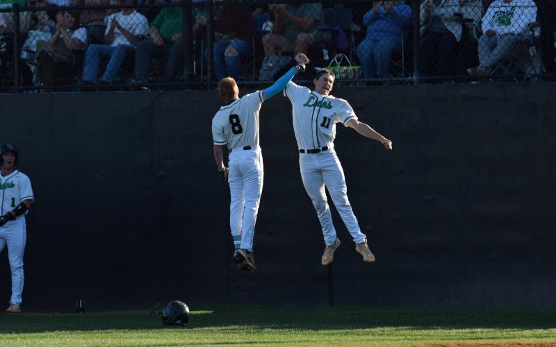 Hudson Huff (No. 9) and Will Dodd (No. 11) celebrate after Huff hit his first career high school home run April 16 against Hebron Christian. Huff, a freshman, hit the home run on Senior Night. (Photo by Scoggins)