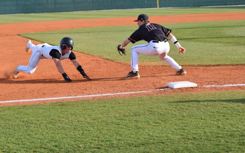Keyes Harbin slides in safely to third in action against Hart County Friday at FCHS in Carnesville. The Lions swept the Bulldogs and have won six consecutive region contests. (Photo by Scoggins)