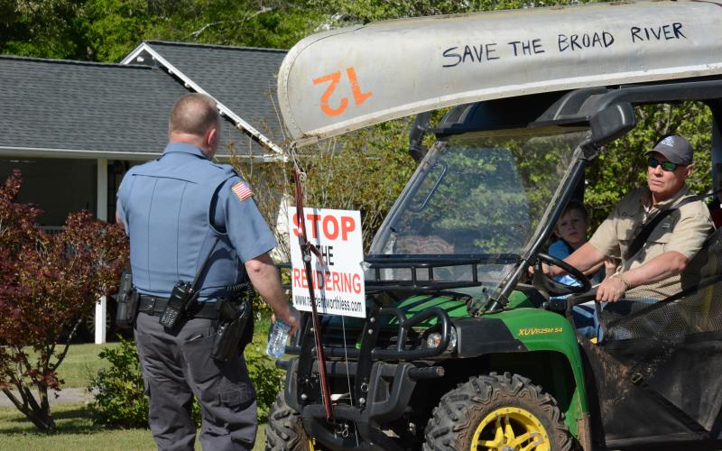 Franklin Springs Police Chief Kevin Thompson (left) talks with Daniel Tompkins while working to get an overflow crowd parked prior to Tuesday night’s city council meeting. (Photo by Eavenson)