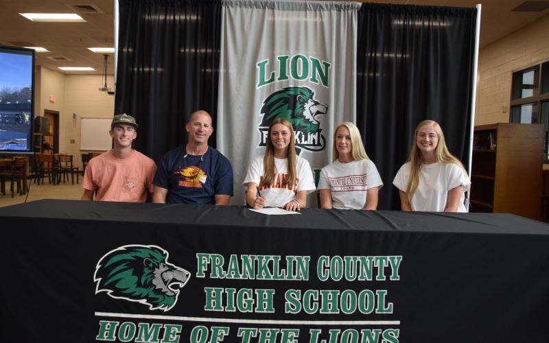 State pole vault champion Macy Moore (seated center) was joined by her family (from left) brother Eli, father Lee, mother Misty and sister Rylee at a scholarship signing ceremony at Franklin County High School. Moore will pole vault for Emmanuel University next year. (Photo by Scoggins)
