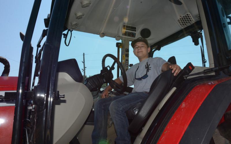 14-year-old Heaton Williams sits in his Massey Ferguson tractor that he uses ion his family’s farm and to bush hog fields and harvest corn for local farmers. (Photo by Charlie Eavenson)