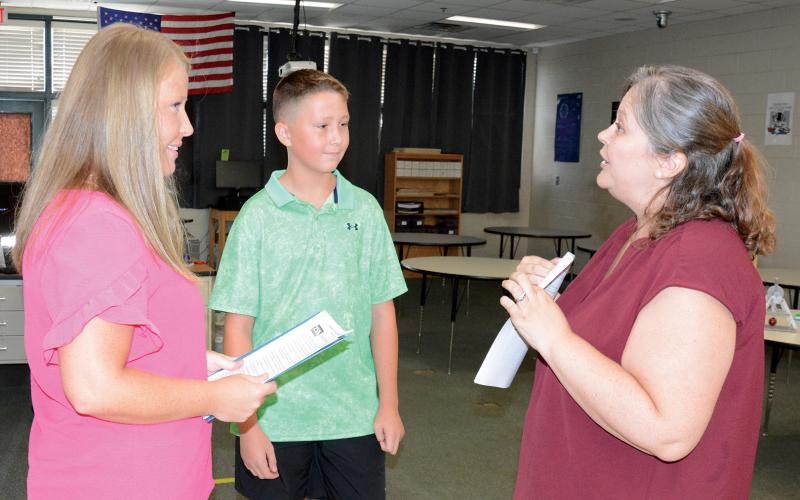 Franklin County Middle School and Franklin County High School held open houses on Tuesday. Information on homeroom assignments, schedules, parking passes, sports teams and clubs were available. FCMS technology and engineering teacher Heather Elo (left photo) explains the Technology Student Association (TSA) to Korbin Reed and his mom, Tiffany Jordan. (Photo by Charlie Eavenson)