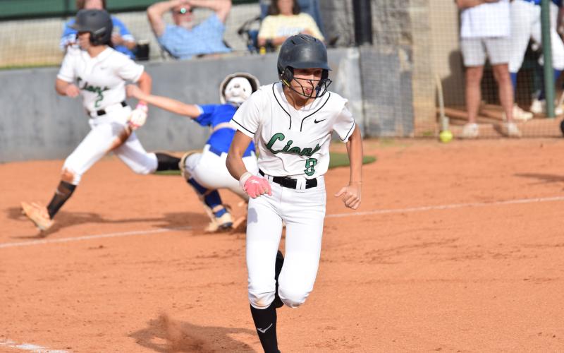 Rylee Gibson runs to first after a bunt as Hannah Horne scores behind her in Franklin’s 12-0 victory over Lake Oconee Academy Monday in Carnesville. (Photos by Shane Scoggins)