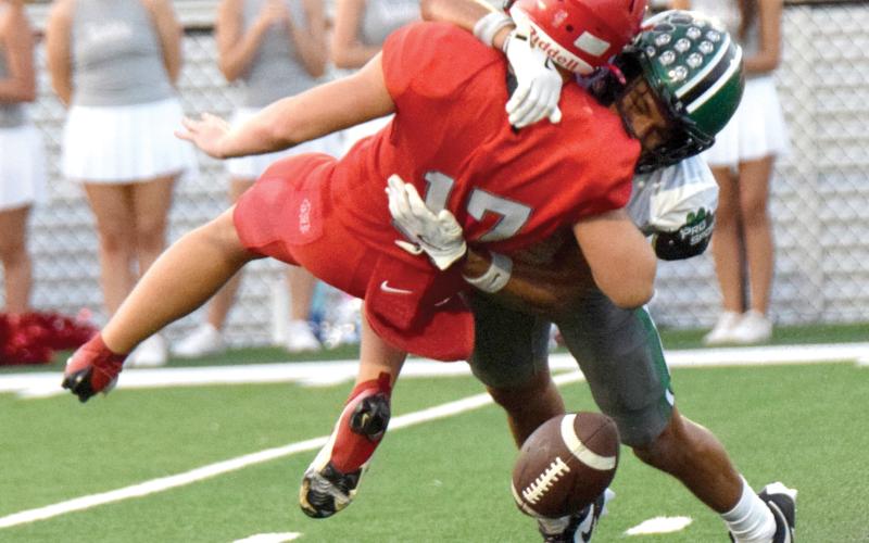 Franklin County High School Lion Nava Ware decleats a Madison County quarterback and causes a fumble during Friday’s scrimmage game in Danielsville.