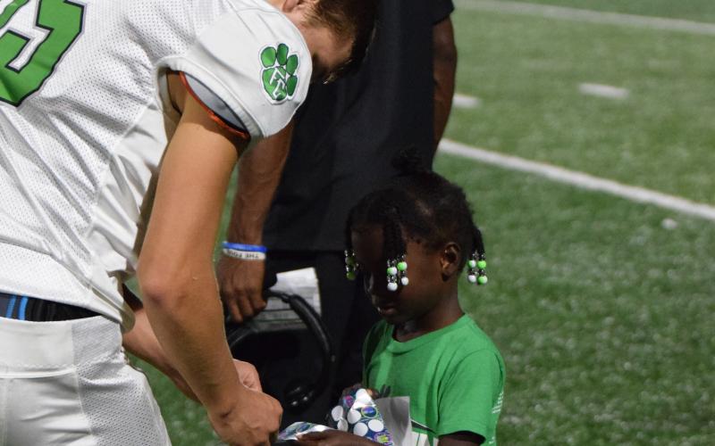 Ayden Brock, daughter of  Franklin County Lions Assistant Coach Deon Brock, handed out congratulatory stickers to the Lions Friday after the team defeated Chestatee 14-7 in overtime in the first contest of the season.