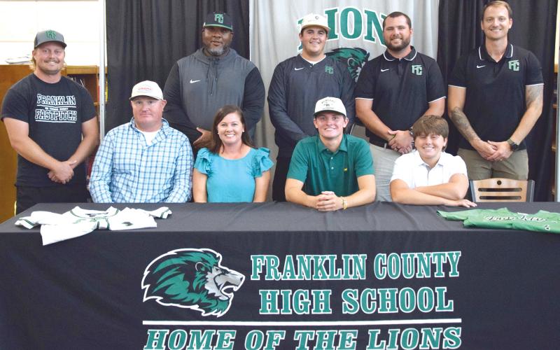 Joining Cade Gibson to celebrate his signing of a baseball scholarship to East Georgia State College are (front, from left) dad Brad Gibson, mother Rebekah Gibson, Cade, brother Nolan Gibson, (back) coaches Ty Tipton, Demond Rivers, Duncan Beasley, Head Coach Ryan Phillips and Drew Phillip. (Photo by Shane Scoggins)