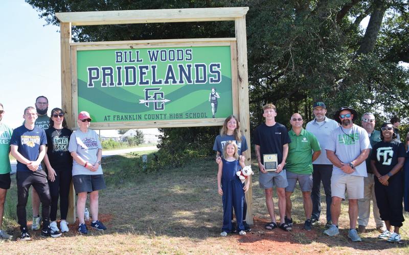 Members of the Wood family were joined Thursday by Franklin County School System officials and cross-country and track coaches for the dedication of the Bill Woods Pridelands Cross Country Course on High Road in Carnesville. (Photo by Shane Scoggins)