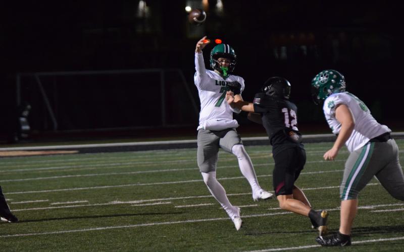 Lion quarterback Knox Whitworth delivers a pass under pressure Friday night in Franklin County’s Region 8AA game against Hebron in Dacula. (Photo by Shane Scoggins)