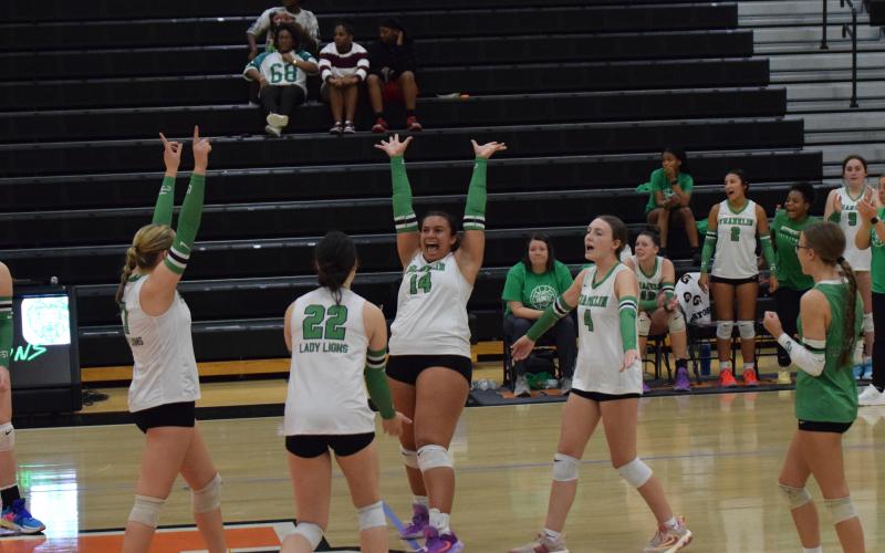 Lady Lion Kallie Thrift (No. 14) celebrates with teammates Callie Frady and Avery Burton after winning a point in Franklin County’s Region 8AA semifinal win over Hart County last week. The win qualified Franklin for the state playoffs for the first time in school history. (Photo by Shane Scoggins)