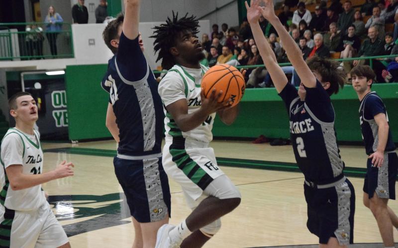 Jeremiah Mayfield goes up for a layup between two Prince Avenue defenders in Franklin County’s home victory Friday. (Photo by Shane Scoggins)