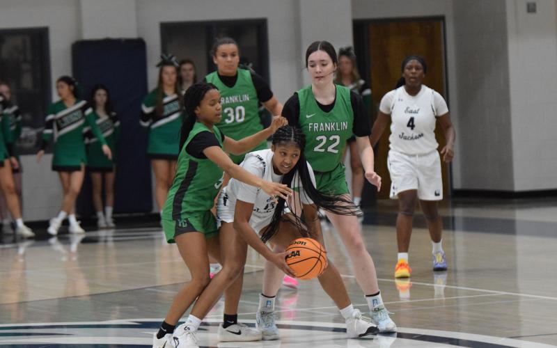 Zy Merritt (left) and Avery Burton (right) surround an East Jackson ball handler during the Franklin County Lady Lions’ win Thursday in Commerce. (Photos by Shane Scoggins)