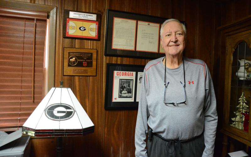 Roy Holland of Lavonia stands with some of his awards and honors he garnered as a basketball letterman for the University of Georgia Bulldogs. (Photo by Charlie Eavenson)