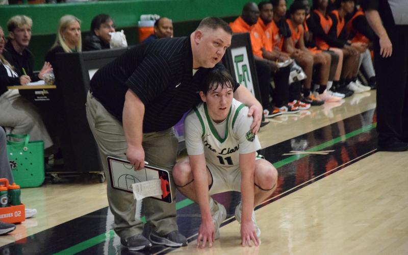 Franklin County Lion Coach Jason Shaver talks with senior Bentley Huff during a break in play during Friday’s win over Hart County in the Lions Den. (Photo by Shane Scoggins)