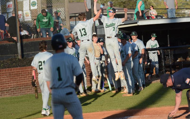 Gavin Holman (No. 13) and Eli Moore (No. 7) celebrate after Holman’s home run against Hart County Monday in Hartwell. (Photo courtesy of Benjamin London of The Hartwell Sun)