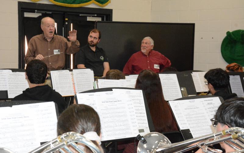 FCHS’s first band director Bill Martin (left) was back in fine form Friday, leading current students in the high school band room. Current FCHS Director of Bands Christopher Sampson and Mercer Crook, who retired as director of bands at East Hall High School in Gainesville, look on as Martin handles the baton. (Photo by Charlie Eavenson)