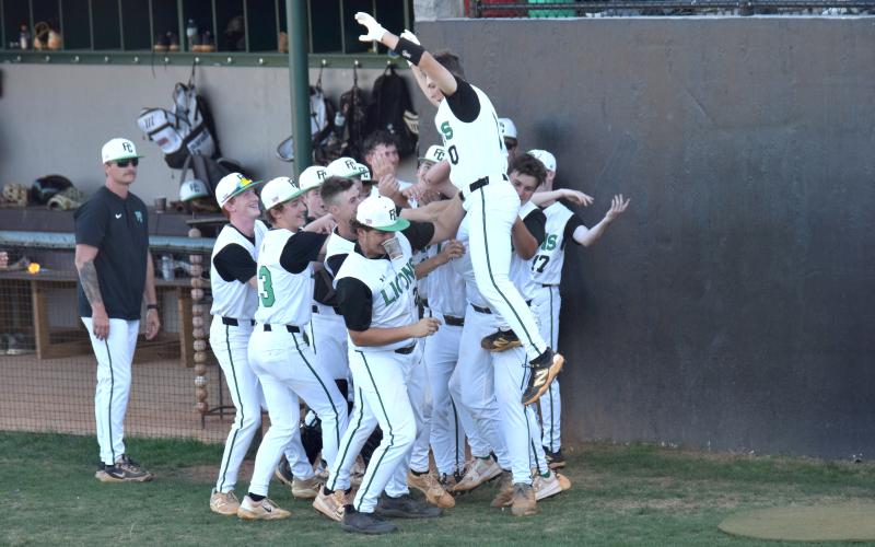 The Franklin County Lions celebrate after a home run by Easton Gailey Friday against Hebron Christian. The Lions will travel to Blairsville Friday for the first round of the state playoffs against Union County. (Photo by Shane Scoggins)