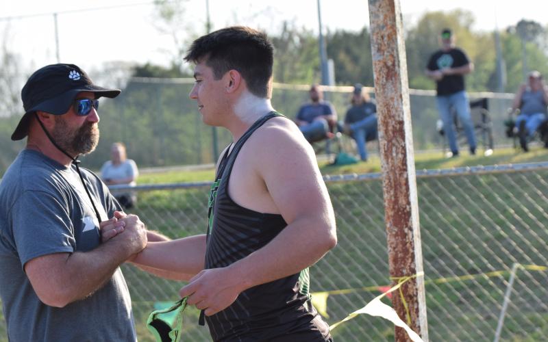 Coach Clint Tanner (left) congratulates Candler Stone after Stone broke the school record for shot put Thursday at FCHS. Tanner, who coaches Stone, set the previous record in 1999. (Photo by Shane Scoggins)