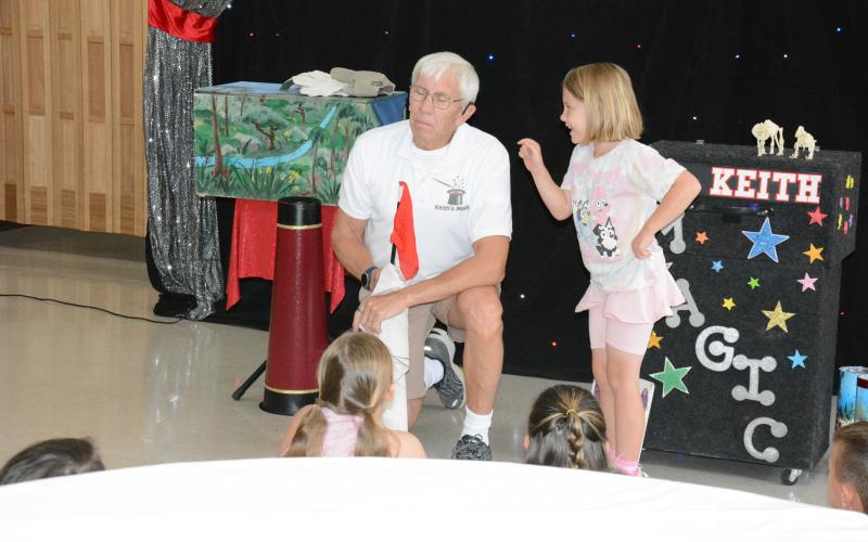 Katherine Gray (top photo) helps out magician and ventriloquist Keith Karnok as he performs for the Lavonia Carnegie Library’s summer reading program on Tuesday.