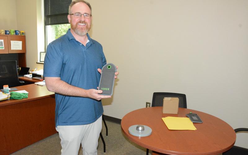 Franklin County High School Principal Curtis Chitwood shows off the school’s YONDR Pouch system to prevent the use of electronic devices during the school day. (Photo by Charlie Eavenson)
