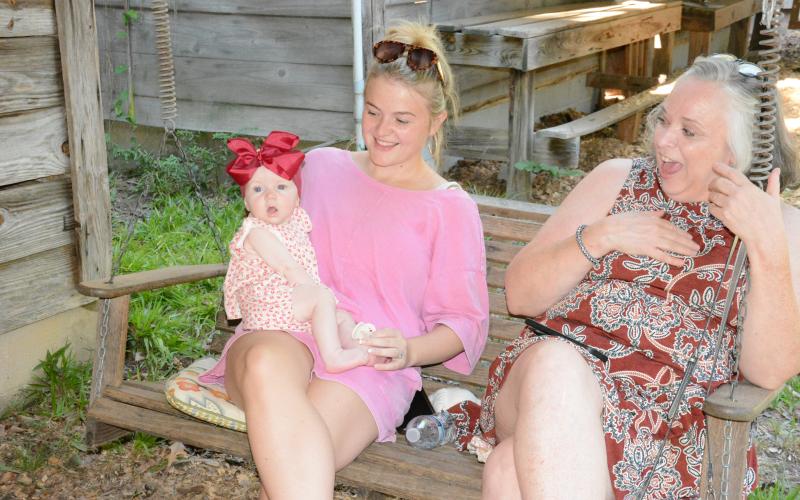 Rebecca Milford Floyd laughs at the antics of little Landrie Armour, who is being held by her mother Alyssa Ellard.