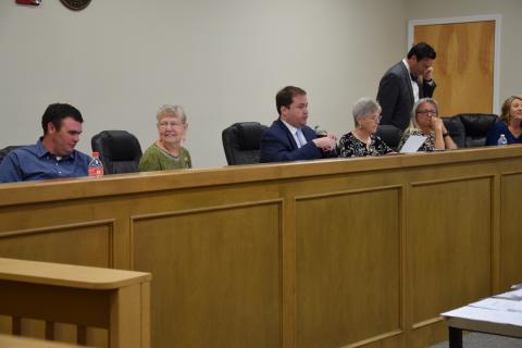 Franklin County Board of Elections and Registration members (from left) Roman Strickland, Alice Black, Chairman Doug Kidd, Sherry MacDonald and Angela Whidby (with County Attorney Bubba Samuels and Elections Superintendent Gina Kesler) prepare to listen to tesimony following a break in a hearing Wednesday on a challenge to the residency of Lee and Sheena Strickland.
