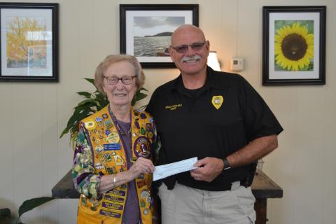 The Lavonia Lions Club, in conjunction with the Lavonia Police Department, will sponsor National Night Out  today beginning at 5 p.m. in downtown Lavonia. Pictured is Lavonia Lions Club member Margaret Ayers presenting Lavonia Police Chief Bruce Carlisle with a check for the event. (Photo by Eberhardt)