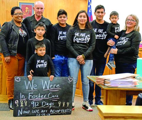 Steve and Angela Whidby completed the adoption Thursday of six siblings who had been in foster care with the family since 2017. Pictured in the courtroom at the Franklin County Courthouse are (front) Angel (holding sign) Felipe, (back) Case Manager Stephanie Tate, Steve Whidby, Edwin, Jennifer, Jose, Emmanuel and Angela Whidby. It was the largest single adoption in county history. (Photo by Scoggins)