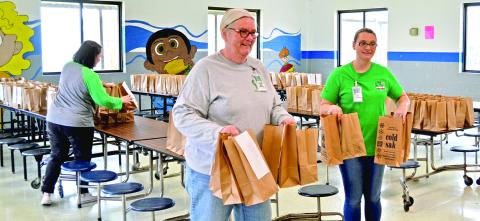Members of the Franklin County School System’s nutrition department tote lunches after a program began in March to provide meals to students in the community. By the time the program ended June 23, the system served more than 200,000 meals.
