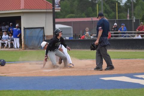 Evan Herring looks to the umpire just moments before being ruled safe on a play at the plate Friday against Oconee County in Watkinsville. (Photo by Scoggins)