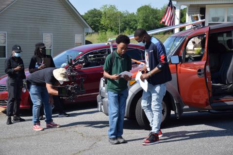 Director David Nix Jr. (right) talks with an actor as crews set up a camera to shoot a movie scene Sunday in Crestview Heights in Carnesville. (Photo by Scoggins)