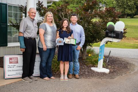 Carlie Christian was honored by the Franklin County Farm Bureau recently for winning the Georgia National Junior Livestock Show. At a ceremony at the Farm Bureau office in Carnesville, Carlie was presented a hat, a championship buckle and her prize money by Georgia Farm Bureau President Tom McCall. Carlie was joined by her parents Leslie and Bryan. Carlie has been a regular award winner in livestock shows and keeps her prizes on display at her home.