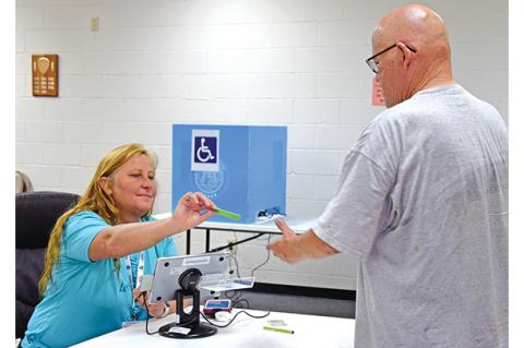 Poll worker Teresa Swing checks in Carl Whitworth to vote in Canon’s special election on Tuesday afternoon. (Photo by Sinclair)
