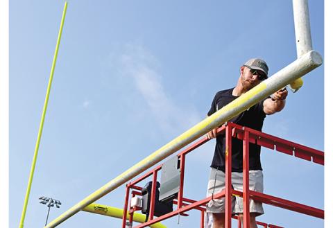 New Franklin County Lion Head Coach Parker Martin worked Sunday to paint the goal posts at Ed Bryant Stadium. (Photo by Scoggins)
