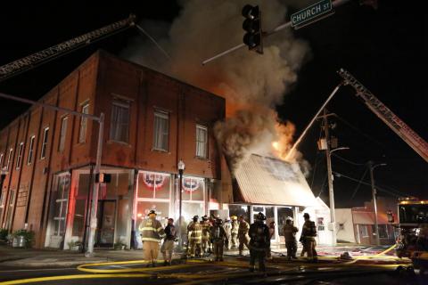 Firefighters work to extinguish a fire Tuesday in the former Royce Theatre building in downtown Royston. The building was being used for storage at the time of the fire, which was contained to just that building. For more photos from the fire, see Pages 4-5A. (Photo by Rose Scoggins)
