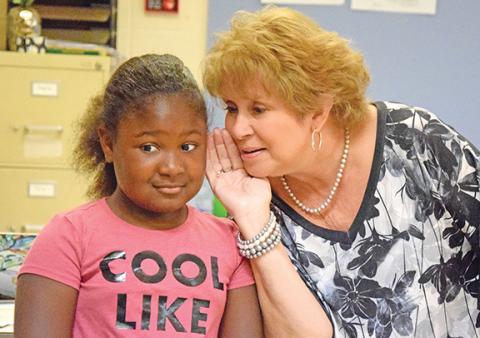 Royston Elementary teacher Regina Corn shares a secret with Amiracle Roebuck — she has board games hidden in her third grade classroom. (Photo by Sinclair)