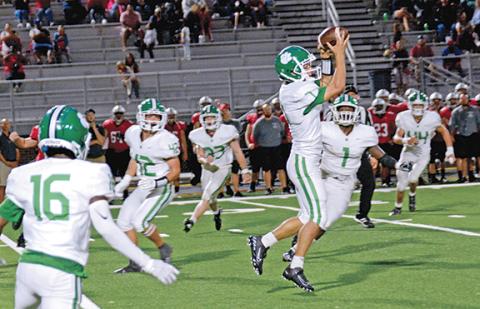 Lion Dee Oliver jumps up to snag an interception in the third quarter of Friday's game at Jackson County. Oliver returned the interception for his second touchdown of the game. His first came on the second-half kickoff return. (Photo by Scoggins)