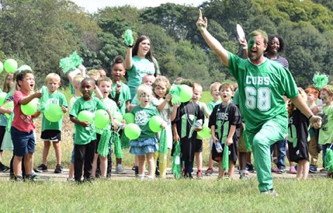 Lavonia Elementary School kindergarten teacher Tyler Matthews leads kindergartners in a cheer during Thursday's Lion Walk at Lavonia Elementary School. (Photo by Sinclair)