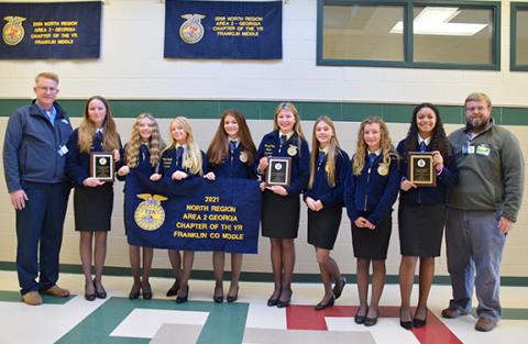 Kent Benson and Brian Elrick present Franklin County Middle School FFA officers Ava Gray, Rylie Sanders, Meghan Langley, Darby Roach, Camryn Childs, Scarlett Killen, Callie Walker, Ella Maisonneuve with the chapter’s 2021 Area 2 awards. (Photo by Sinclair)