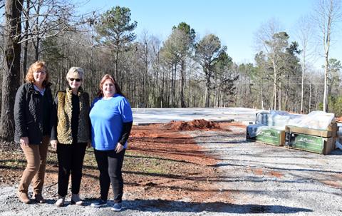Director of Donor Relations and Fundraising Lucy Floyd, Founder and Executive Director Beverly Oxley, and Program Director Tanya Hipp show the progress made on the construction of the new facility for The Ark Family Preservation Center. Utilities were set, and lumber was waiting to start framing when weather permits. (Photo by Sinclair)