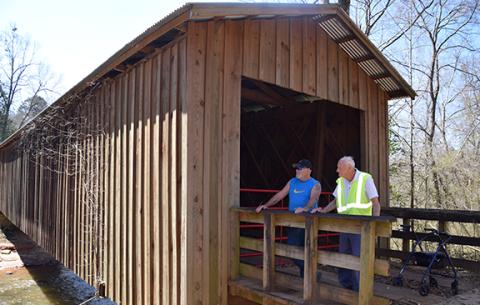 Tim and James W. Brown take a moment to watch the creek as they visit Cromer’s Mill Covered Bridge. (Photo by Sinclair)