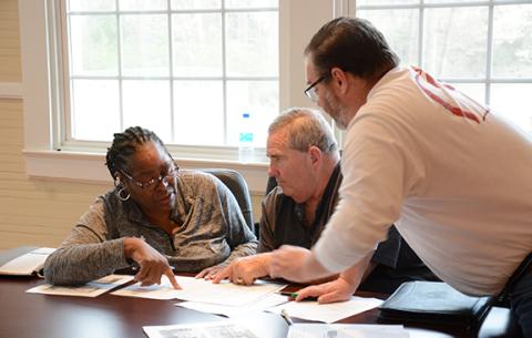 Carnesville council members Patsy Watkins, Mike Barrett and Wesley Dove go over plans for a 200-lot subdivision on 156 acres that developer Aubrey Lunsford has asked to be annexed into the Carnesville city limits. The council will vote on the proposal at its meeting April 5. (Photo by Scoggins)